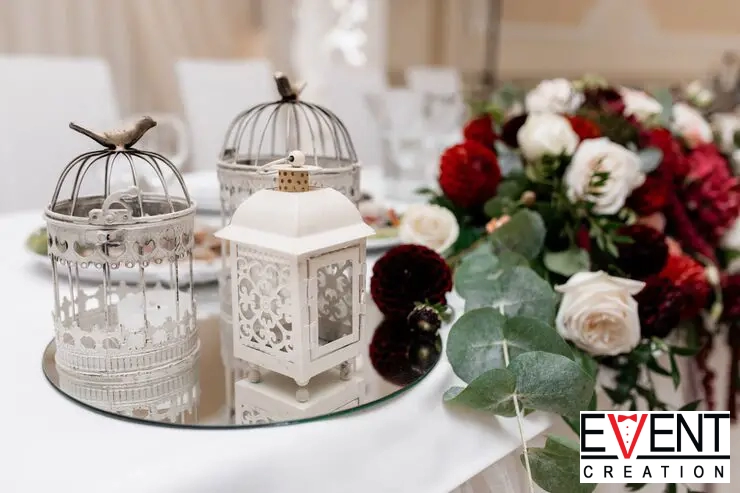 An close-up of a wedding table centerpiece featuring vintage-style on a circular mirrored tray.